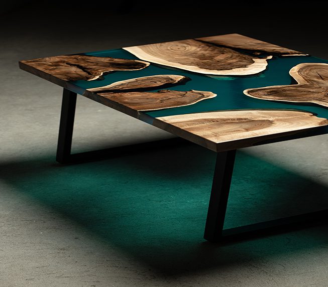 Expensive vintage furniture. The table is covered with epoxy resin and varnished. Luxury quality wood processing. Wooden table on a concrete background. A nautical epoxy river in a rectangular slab.